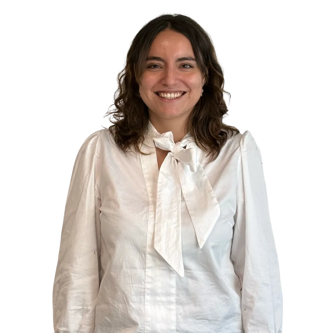 Retrato corporativo de Claudia Villari sonriendo, con blusa blanca de manga larga sobre fondo blanco, en una pose profesional.