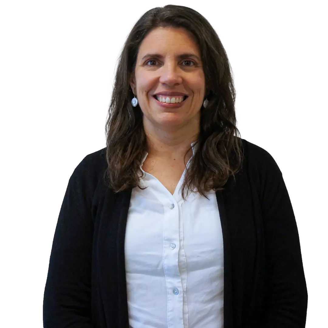 Retrato corporativo de Carmen Montes sonriendo, con blusa blanca y cárdigan negro sobre fondo blanco, en una pose profesional.