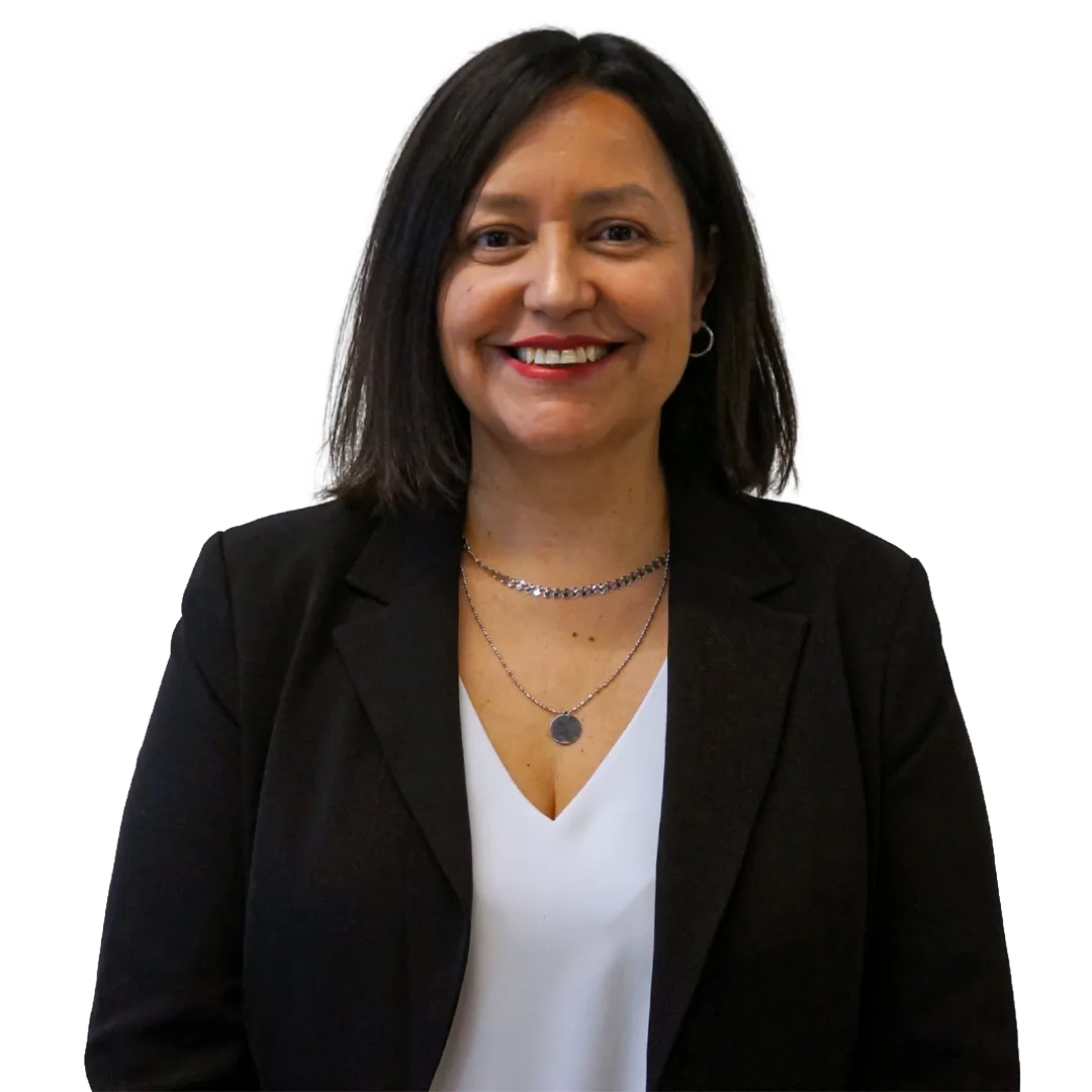 Retrato corporativo de Olga Mardones sonriendo, con blazer negro y blusa blanca sobre fondo blanco, en una pose profesional.