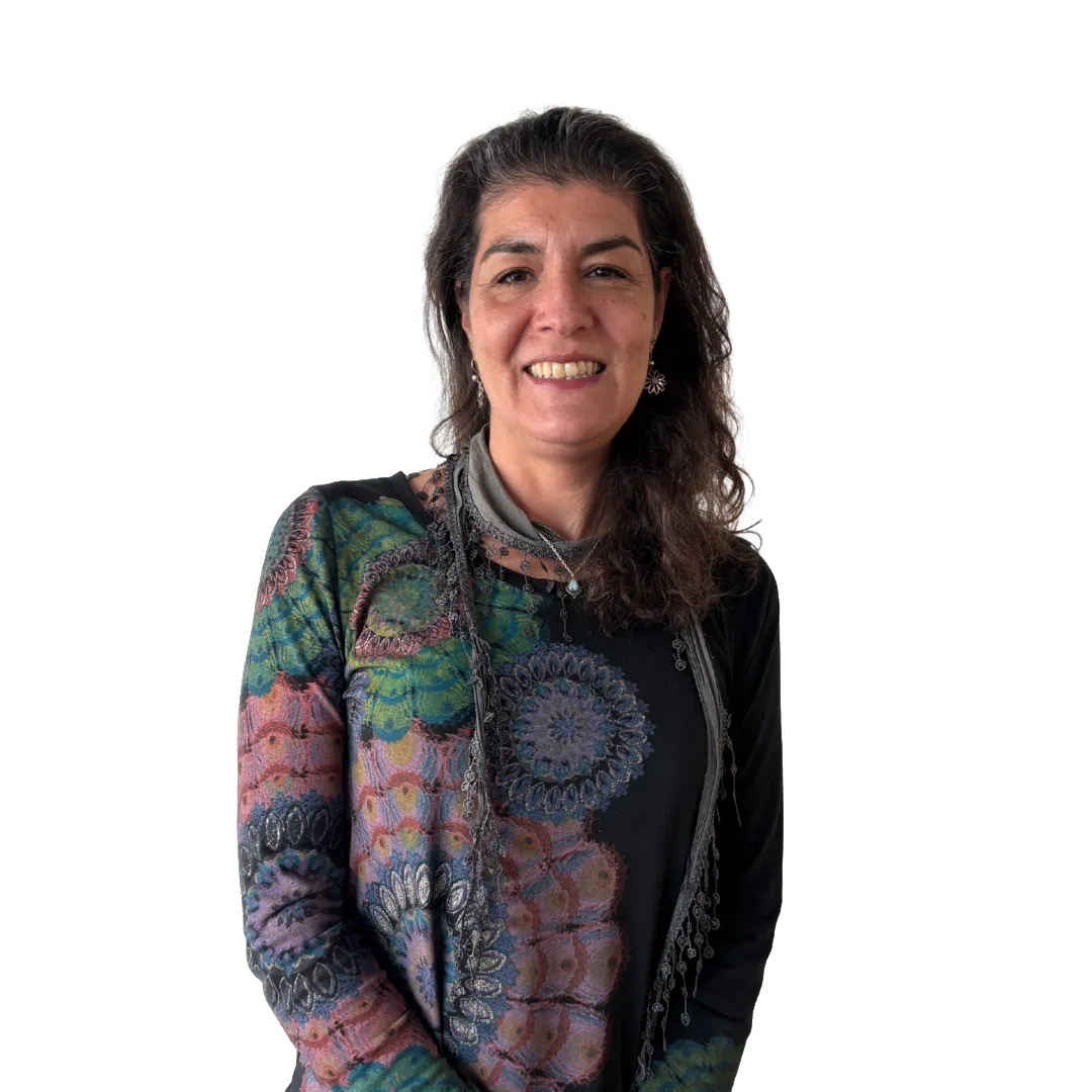 Retrato corporativo de Pamela Aracena sonriendo, con blusa estampada multicolor y pañuelo gris sobre fondo blanco, en una pose profesional.