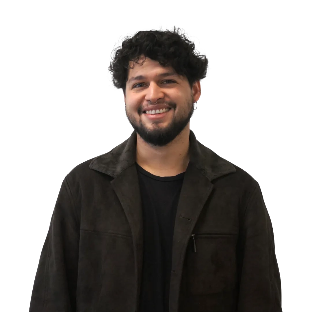 Retrato corporativo de Luis Gavilán sonriendo, con chaqueta café y polera negra sobre fondo blanco, en una pose profesional.