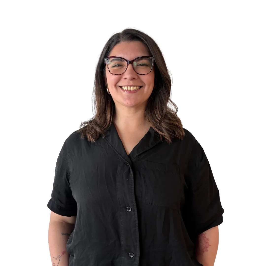 Retrato corporativo de Camila Uribe sonriendo, con lentes y blusa negra de manga corta sobre fondo blanco, en una pose profesional.