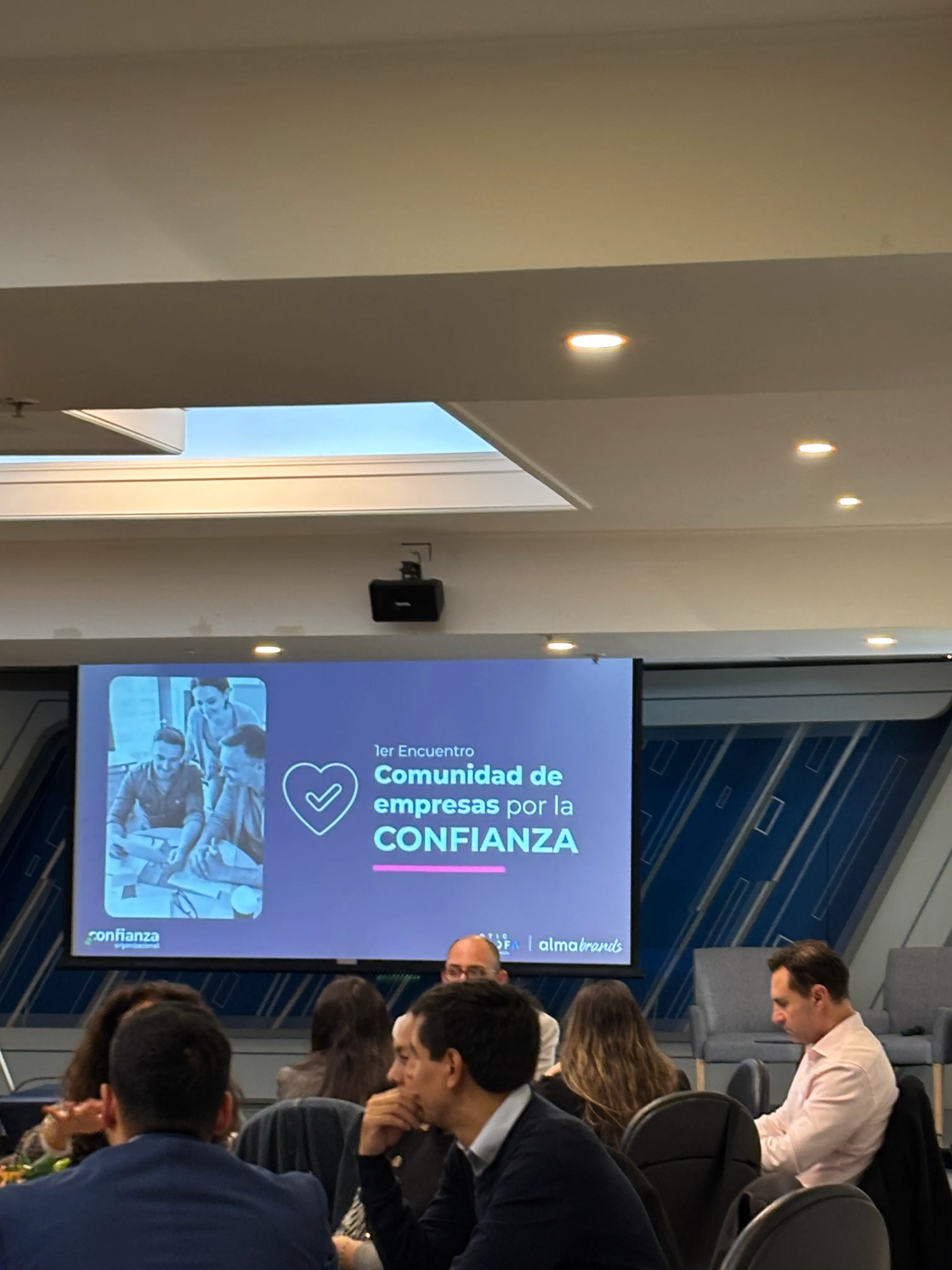 Pantalla principal con la presentación del Primer Encuentro de la Comunidad de Empresas por la Confianza antes de una actividad.